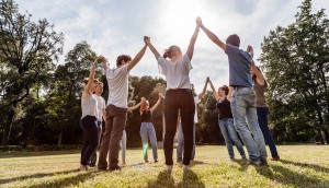Group of friends at the park holding hands and rise up